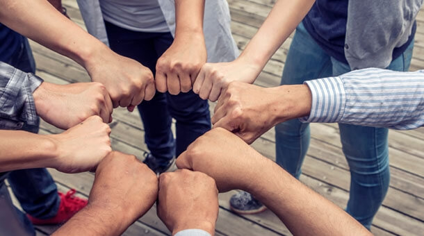 Team of people joining hands in a circle